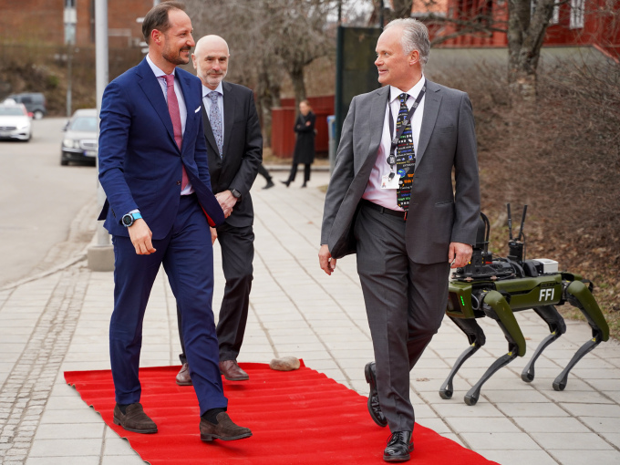 Kronprinsen ønskes velkommen av museumsdirektør Frode Meinich, styreleder Dag Terje Andersen og robothunden Freke. Foto: Liv Anette Luane, Det kongelige hoff